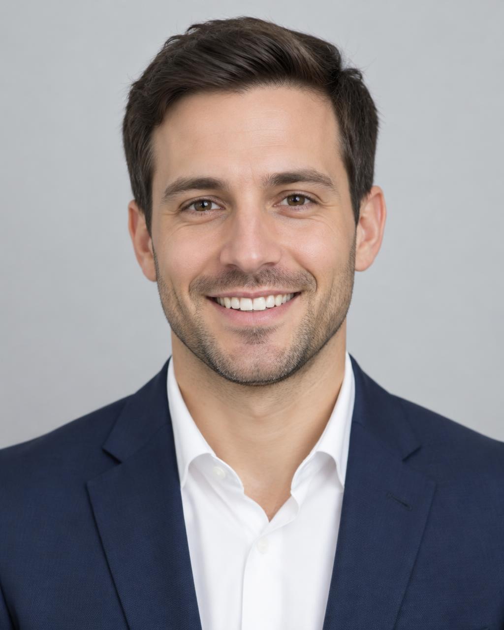 Front-facing portrait of the groom in a navy suit against a gray background